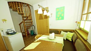 A compact kitchen with a wooden table, a built-in oven, and a small refrigerator. A spiral staircase leads to an upper level. - Apartment With Panoramic Views in Fiss (Fiss)