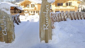A snow-covered entrance with wooden posts labeled "Chalet" and "Rustika." - Chalet in ski Area in Wagrain With Sauna and Pool (Wagrain)