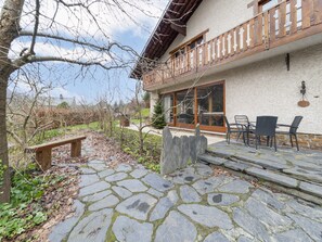 A stone pathway leading to a wooden bench and a patio area with outdoor furniture. - Gite in Belgium Near Scenic Hiking Trails (Vresse-sur-Semois)