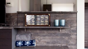A rustic wooden wall with a framed nautical-themed artwork, two decorative candles, and a folded blanket. - Bungalow Near De Alde Feanen With Spa (Earnewald)