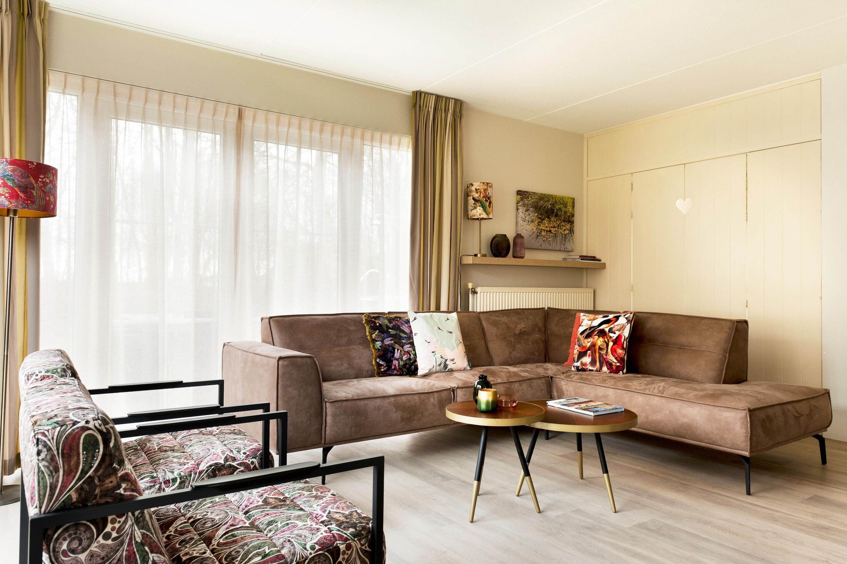 A living room with a sofa, armchair, coffee table, and a radiator.