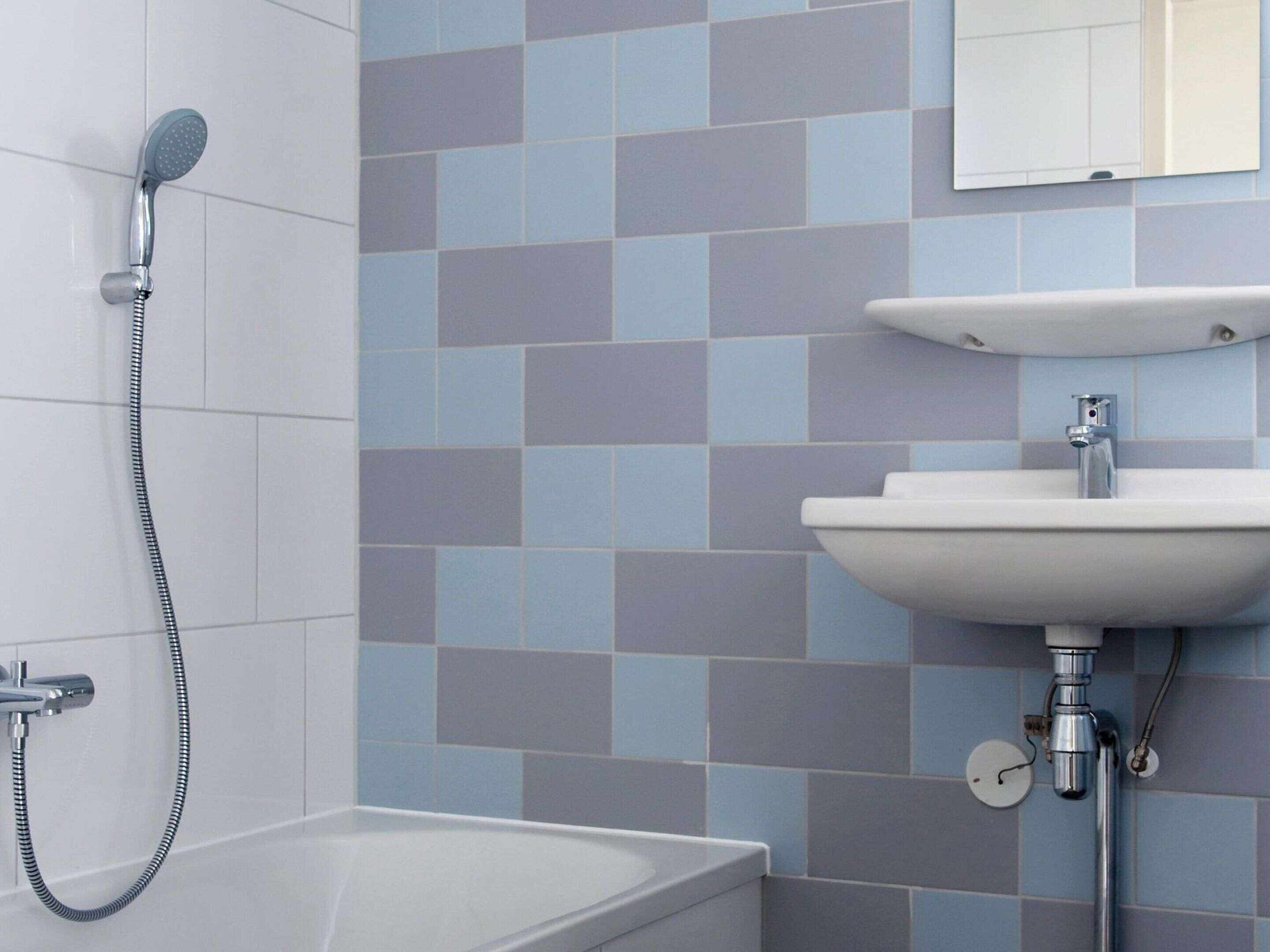 A bathroom with a shower, sink, and toilet.