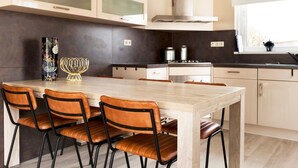 A modern kitchen with a central island, four chairs, and a large window. - Bungalow Near De Alde Feanen With Spa (Earnewald)