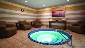 A spa room with a small pool, brown armchairs, a clock, and a painting on the wall. - Two Full Room at a  Hotel (Las Vegas)