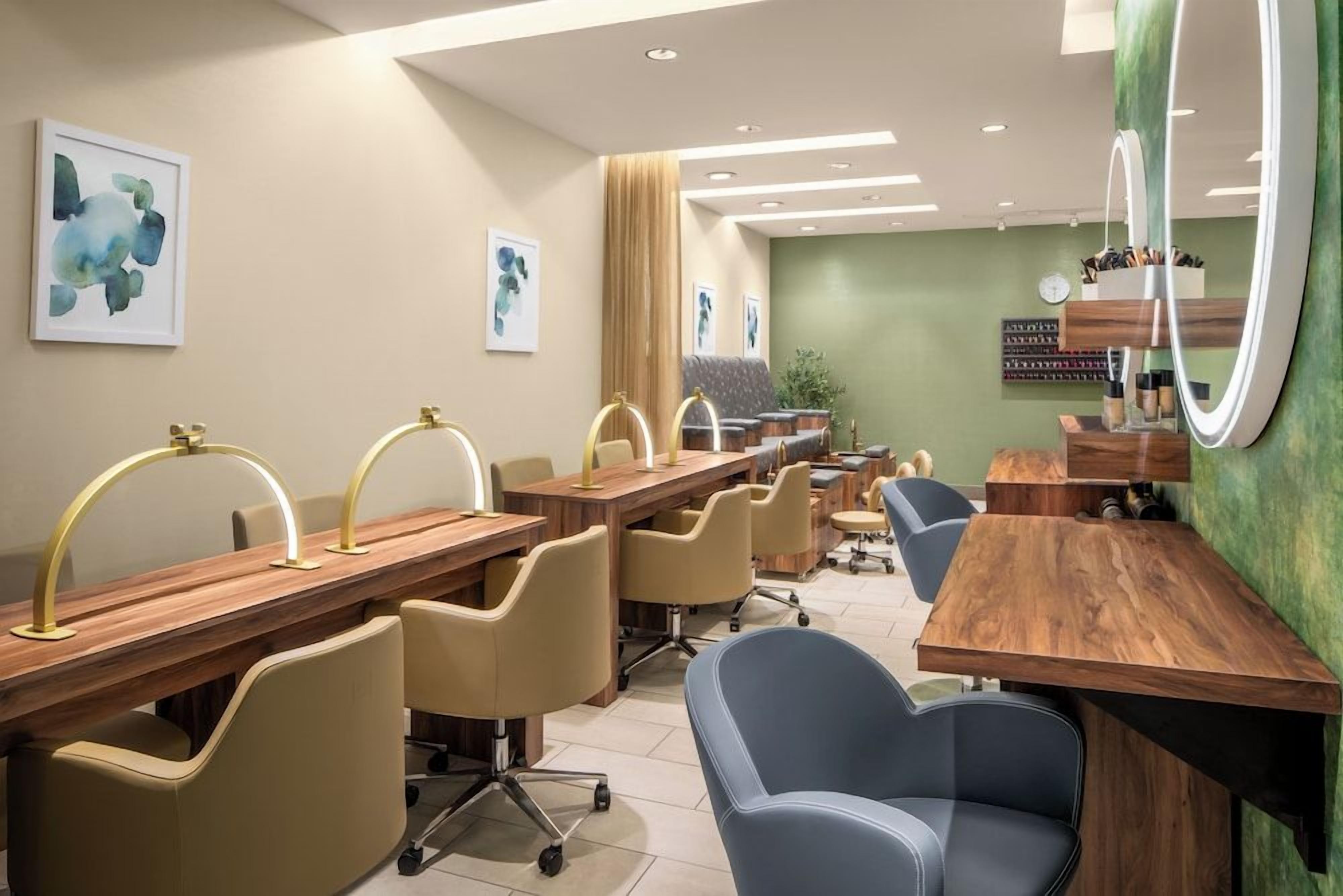 A salon with multiple stations, each with a chair and a vanity.