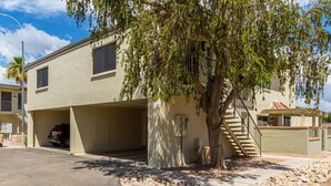 A two-story house with a covered garage, a tree in front, and a staircase leading to the second floor. - Newly Remodeled, Cozy & Private Condo - Beautiful Fountain Hills - Near Fountain (Fountain Hills)