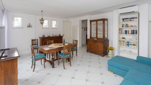 A dining area with a wooden table and chairs, a cabinet with glass doors, and a bookshelf. - Villa Lelle Amalfi (Amalfi)