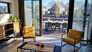 Un soggiorno moderno con divano, tavolino da caffè e zona pranzo con sedie e tavolo apparecchiato per due persone.