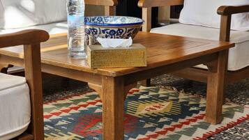 A wooden table with a blue and white bowl, a clear water bottle, and a tissue box.