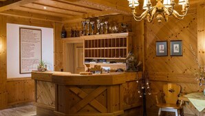 Un intérieur en bois avec un comptoir d’accueil, un lustre et des tableaux encadrés accrochés au mur.