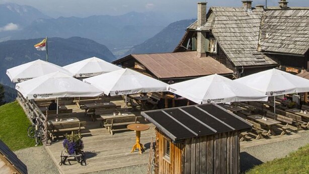 A mountain lodge with outdoor seating and a view of the mountains. - Holiday Home Bodensdorf Near Gerlitzen Ski Area (Steindorf am Ossiacher See)