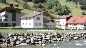 Una vista sul fiume, con un muro di pietra e edifici dall'architettura tradizionale.