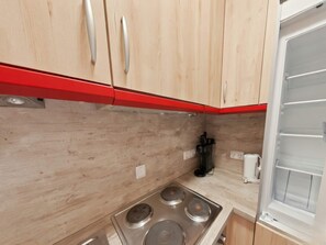 Une cuisine avec des meubles en bois, une cuisinière à gaz et une machine à café.