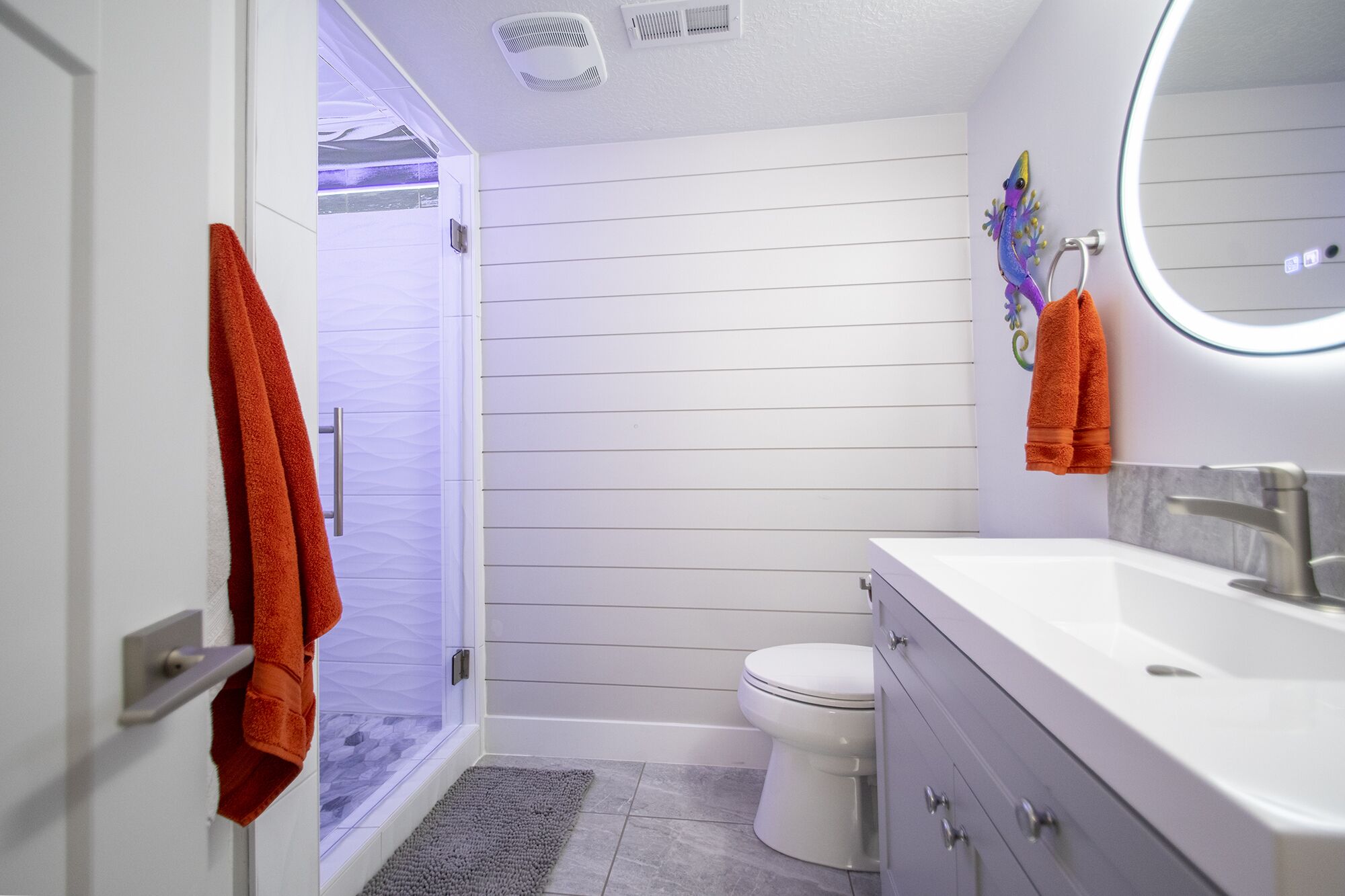 Une salle de bain avec douche, toilettes et lavabo.