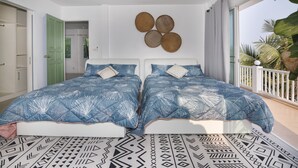 A room with two beds, a balcony with a railing, and a view of palm trees. - Château Du Soleil Phala (UMPER Ban Chang)