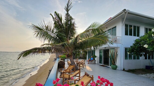 A beachfront property with a patio, lounge chairs, and a view of the sea. - Château Du Soleil Phala (UMPER Ban Chang)