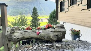 A rustic wooden bench with flowers and a heart, set against a mountainous backdrop. - Pretty Apartment in Mittersill With a View (Mittersill)