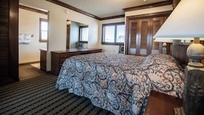 Une chambre à coucher avec un grand lit, une commode, un miroir et une fenêtre.