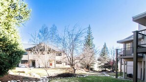 Un quartier résidentiel comprenant une maison à deux étages, un petit jardin avec une pelouse et une rangée d’arbres.
