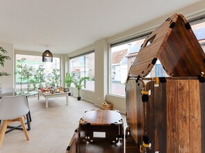Enjoy a spacious room with a large window offering a view of the street outside, a wooden playhouse, and a clean, minimalist design.