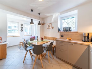 Enjoy a compact yet functional space with a dining area, kitchen, and living space, featuring an oven and coffee machine.