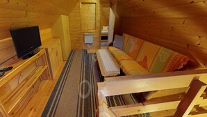 A wooden cabin interior with a television, sofa, and wooden cabinets. - Holiday Home in Bodensdorf by Lake Ossiach (Steindorf am Ossiacher See)