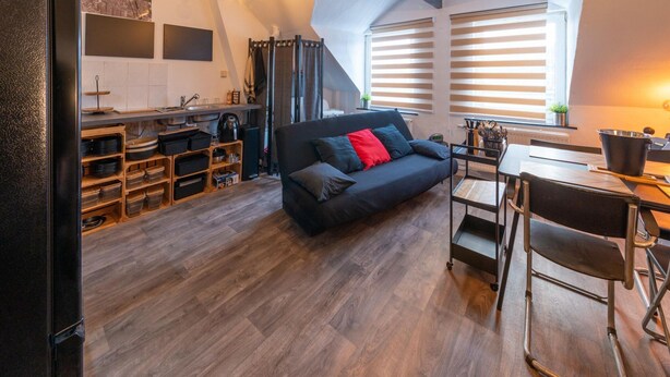 A modern loft apartment with a kitchen, dining area, and a cozy living space with a sofa and a dining table. - Nice Apartment in Liege With Parking (Liege)