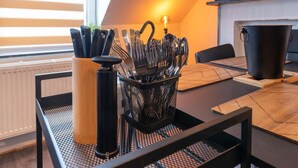 A kitchen area with a black utensil holder, a black kettle, and a black pot on a table. - Nice Apartment in Liege With Parking (Liege)