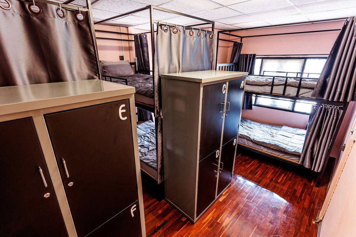 A compact train compartment with bunk beds, a wardrobe, and a small table.