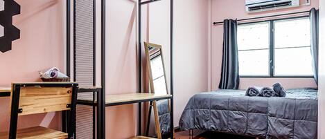 A room with a bed, a desk, a chair, and a window.