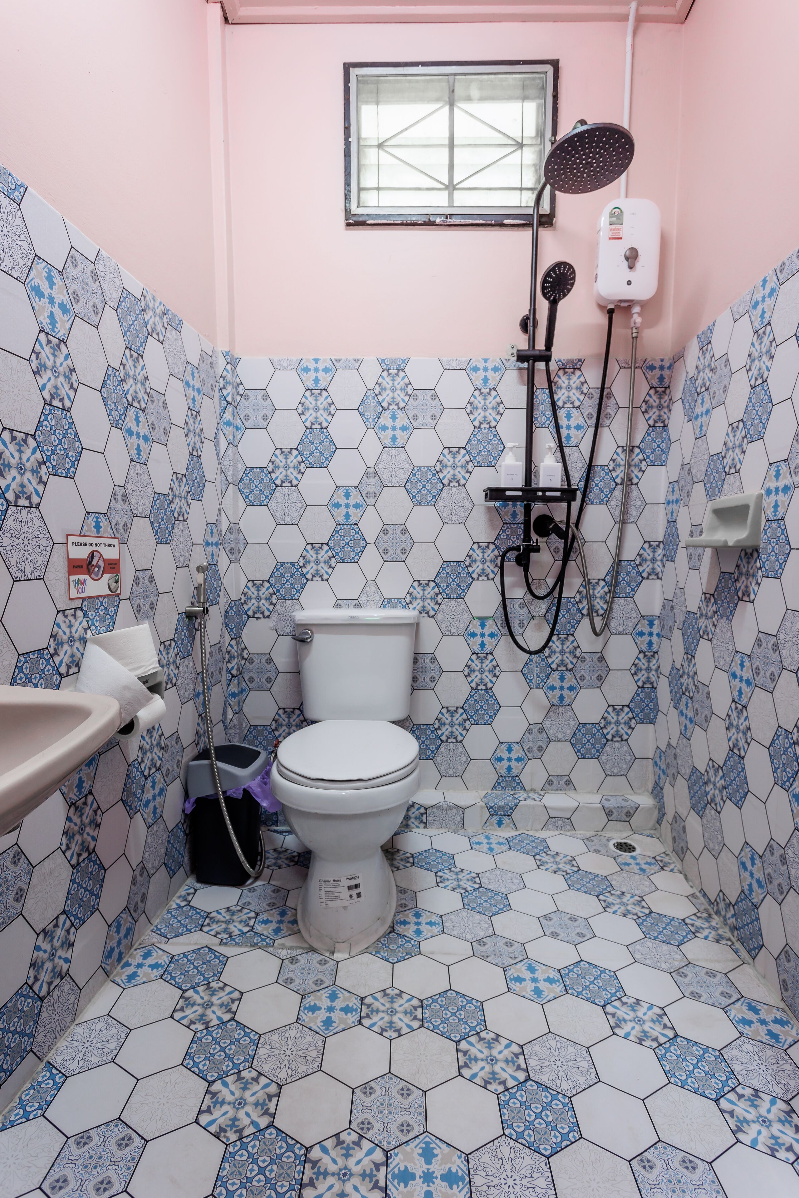 Een badkamer met toilet, wastafel en douche.