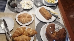 A breakfast buffet with various pastries, fruits, and beverages.