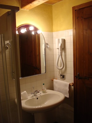 A bathroom with a sink, mirror, and a hairdryer mounted on the wall. - La Thuillettaz B&B Maisons de Montagne  (Saint-Rhemy-en-Bosses)