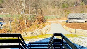A wooden staircase leading to a path surrounded by trees and a stone wall. - Junkerath Romantic Garden Stay (Juenkerath)