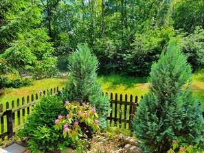 A garden with a wooden fence, various shrubs, and trees. - Delightful Apartment in Goslar With Garden and Terrace (Goslar)