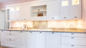 Eine moderne Küche mit weißen Schränken, Granit-Arbeitsplatten und einer integrierten Spüle.