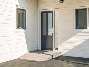 A corner of a house with a door, a window, and a small porch with a ramp. - Cosy Holiday Home in Appelscha With Garden (Appelscha)