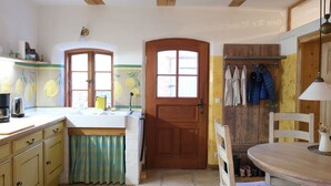 A kitchen with wooden beams, a wooden door, and a window. - Peaceful Escape in Neu Karin (Carinerland)