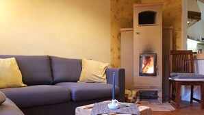 A cozy living room with a sofa, a wooden crate, and a fireplace. - Peaceful Escape in Neu Karin (Carinerland)