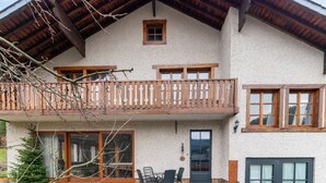 A two-story chalet with a balcony, stone flooring, and wooden railings. - Home in Heart of Belgian Nature (Vresse-sur-Semois)