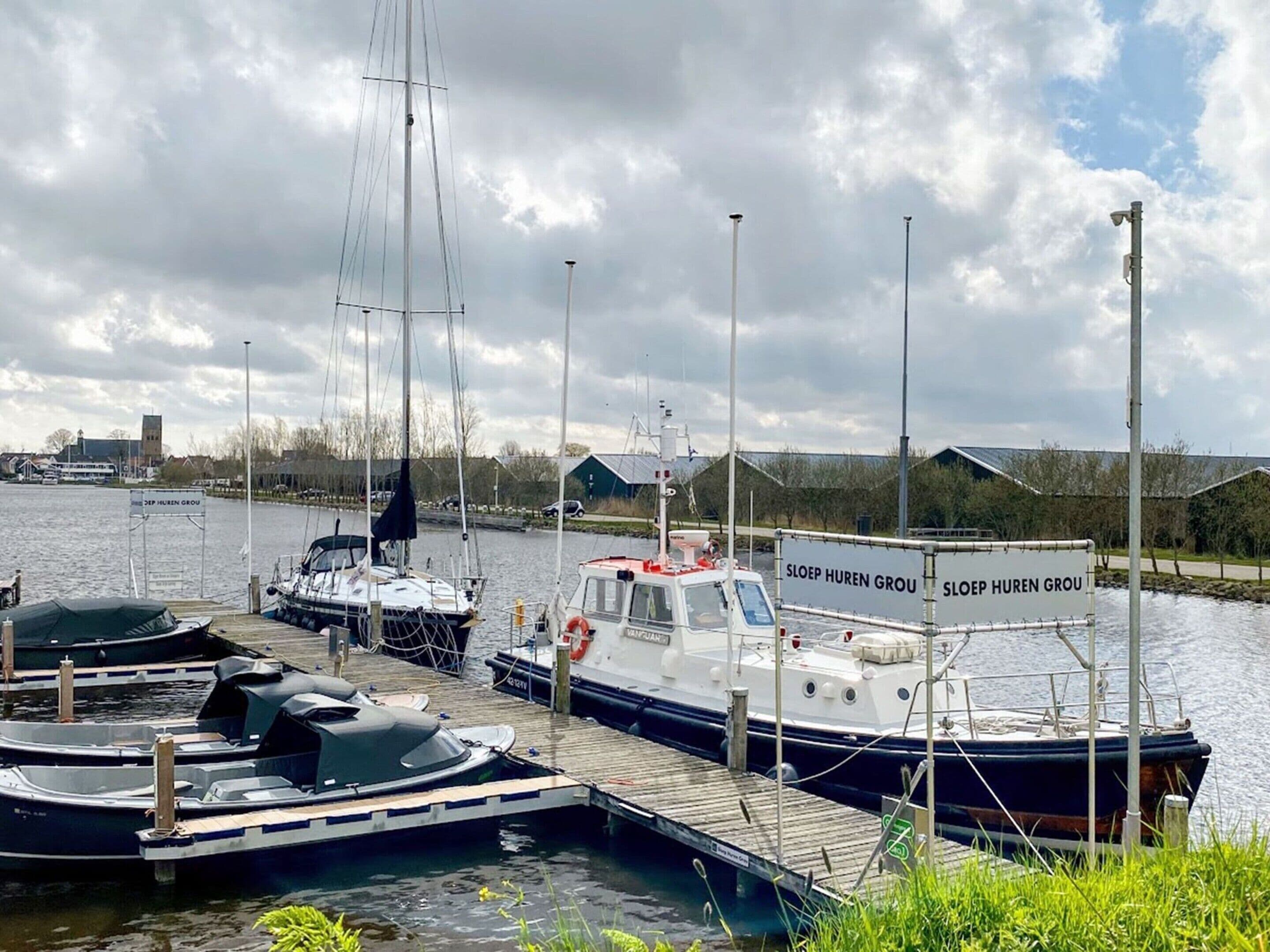 A marina with several boats docked at wooden piers.