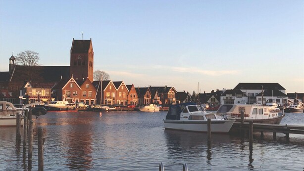 A marina with boats docked, a church with a tall tower, and traditional houses along the waterfront. - Holiday Home in Grou by Pikmeer Lake (Grou)