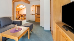 A cozy living room with a sofa, a small table, a TV, and wooden furniture. - Chalet in Mittersill Near Ski Slopes (Mittersill)