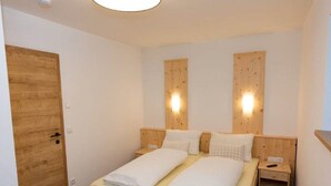 A bedroom with a wooden bed, two bedside tables, and a wooden wardrobe. - Comfortable Holiday Home in Kleinarl (Kleinarl)