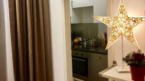 Ett kök med rostfria vitvaror, ett vitt skåp och en dekorativ, stjärnformad lampa.