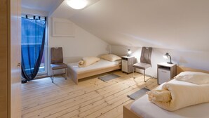 Un dormitorio ático moderno y bien iluminado, con techo inclinado, cama, escritorio y silla.