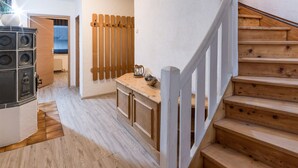 Una escalera que lleva a un segundo piso, un banco de madera y un radiador.