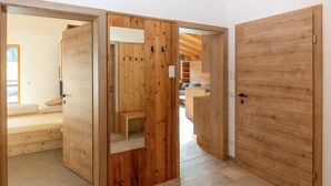 A modern interior with wooden doors, a visible bed, and a seating area. - Apartment in Kleinarl Near Ski Slopes (Kleinarl)