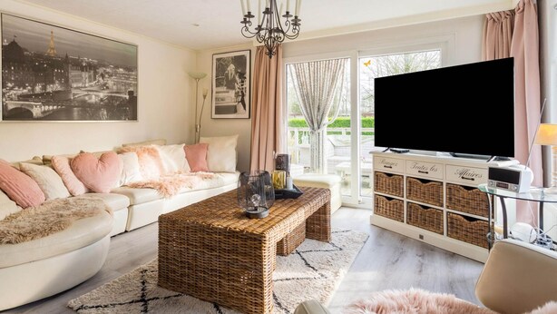 A living room with a sofa, a coffee table, a TV, and a bookshelf.