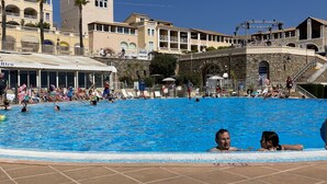 A swimming pool area with a clear blue sky, a stone building, and a white tent. - Villa, golden island view, a stone's throw from the beach. Breathtaking view! (Saint-Raphaël)